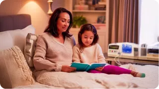 Renal Care Services - Paciente renal mujer tomando terapia de diálisis peritoneal automatizada acompañada de su hija