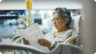 Renal Care Services - Paciente mujer leyendo mientras recibe terapia de hemodiálisis 