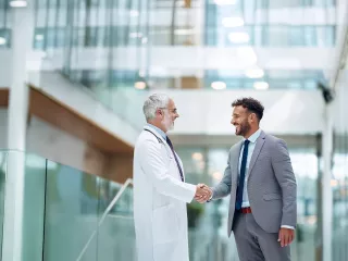 Renal Care Services - Doctor dando la mano a hombre con traje formal