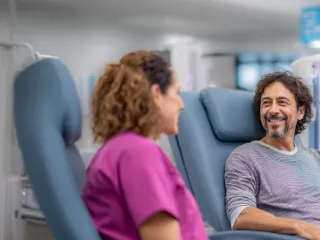 Renal Care Services - Doctora hablando con paciente hombre tomando tratamiento de CRRT